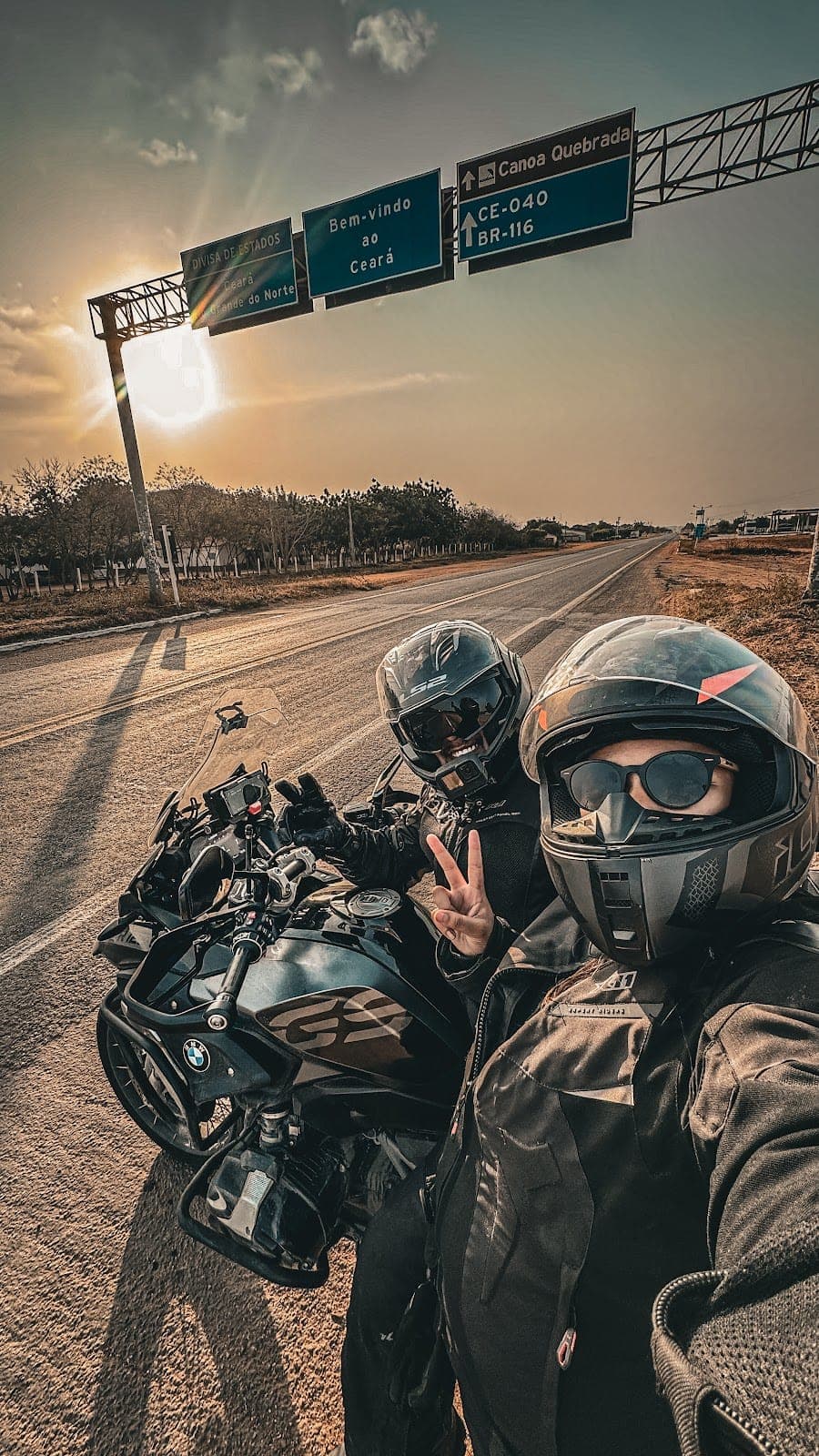 Selfie de capacete com a moto no pôr do sol