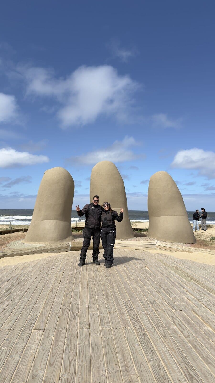 Nós dois em frente à La Mano, na praia de Punta del Este